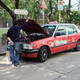 Photo: Michael TracyMechanics doing some sort of fluid replacement on a Toyota Crown taxi.